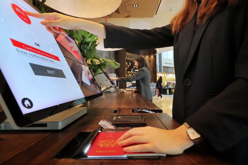 Software para hotel: pessoa fazendo check-in em posto de autoatendimento de hotel